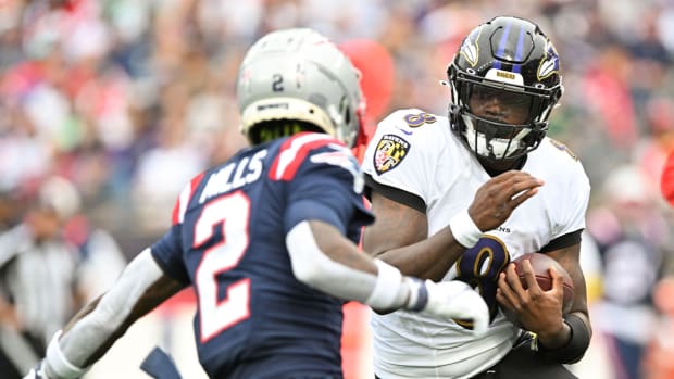 Sep 25, 2022; Foxborough, Massachusetts, USA; Baltimore Ravens quarterback Lamar Jackson (8) runs with the ball against New England Patriots cornerback Jalen Mills (2) during the second half at Gillette Stadium.